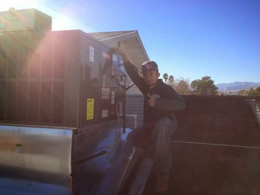 HVAC technician performing Heat Pump Repair on a rooftop unit in Independence